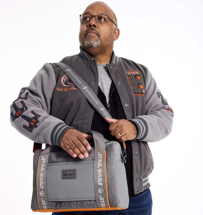 Man with gray beard and glasses wearing the Loungefly COLLECTIV Star Wars Rebel Alliance VRSITY Jacket and wearing the Loungefly COLLECTIV Star Wars Rebel Alliance The EXECUTIV Laptop Bag over one shoulder